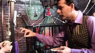 Busty brunette with black fishnet slitting on a hard cock while other slut licking his balls