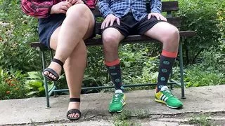 Luxurious stepmother helps her stepson to pee while sitting in the park on a bench