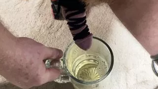 leather bound cock pissing in a beer mug