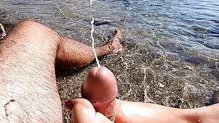 Amateur footjob with cumshot outdoors in a public beach