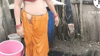 Indian house wife bathing outside