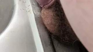 Molliger Junge pisst ins Waschbecken