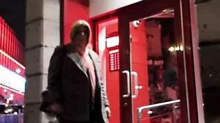 Sissy Schlampe Hure posiert in der Öffentlichkeit vor einem Sexshop