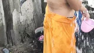 Indian house wife bathing outside