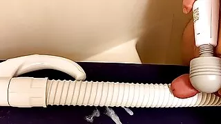 Handmassagegerät Vibrator, der einen kleinen Penis auf einen Staubsaugerschlauch drückt und darauf Sperma abgibt