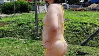 She's walking outdoor wearing micro biquini for many workers see