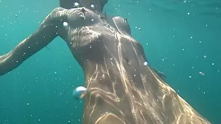 Nude model swims on a public beach in Russia.
