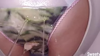 Wet pussy pissing through panties while sitting on toilet