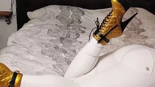 BWB MissBigButt modeling her collection of boots in white freddy pants and black shiny latex corsage in bed